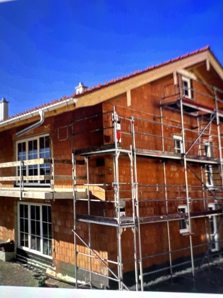 A kitchen under construction with white cabinets and a large island.