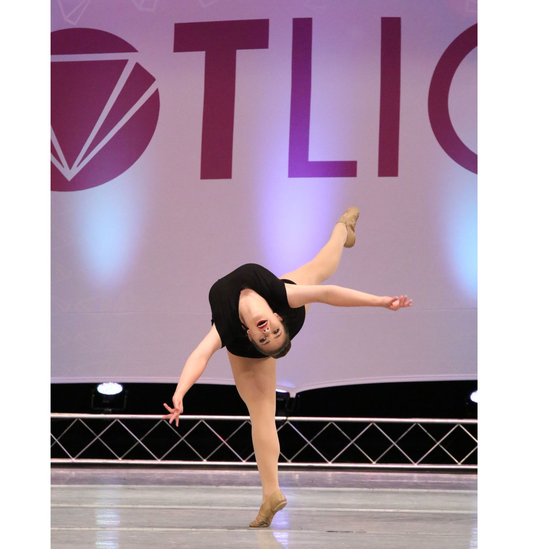 A woman is dancing in front of a sign that says tlic
