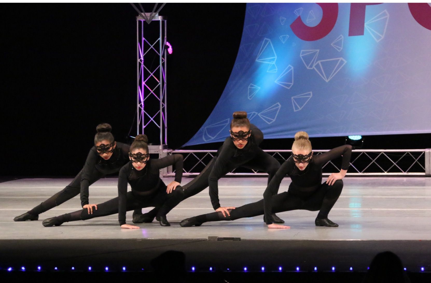 A group of young girls are performing a dance on a stage.