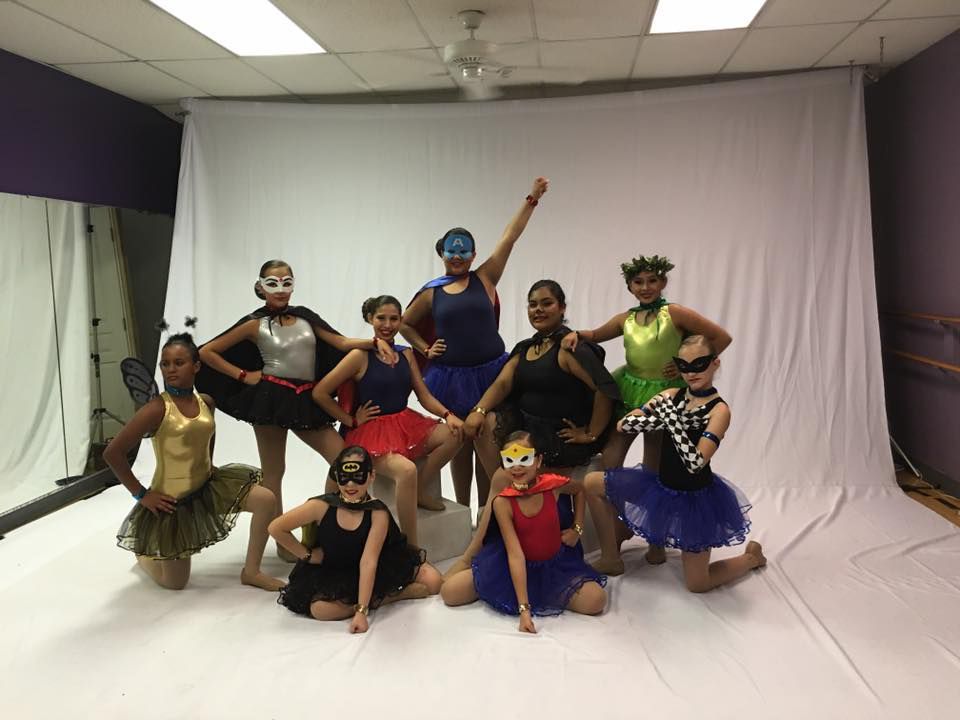 A group of young girls are posing for a picture in a dance studio.
