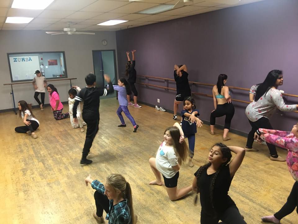 A group of children are dancing in a dance studio.