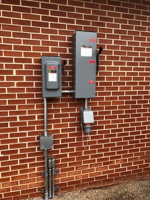 A brick wall with two electrical boxes on it