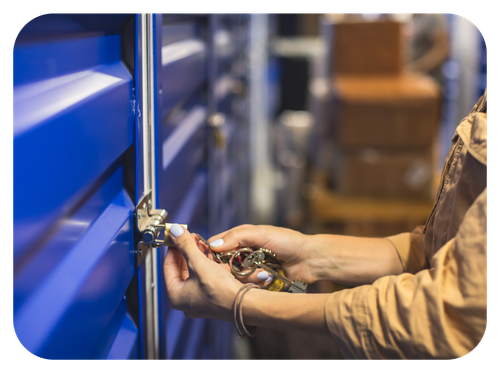 Man using a laptop and credit card while a couple holds a moving box.