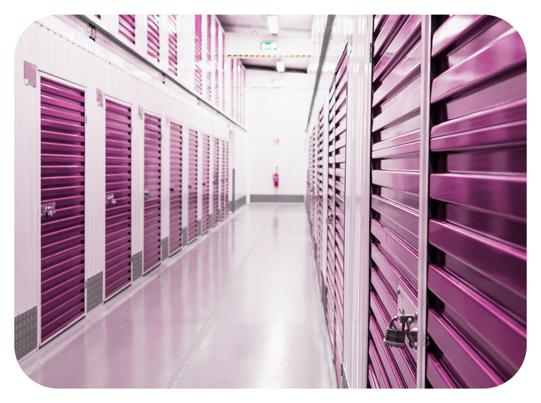 Woman using phone, smiling, beside a person sealing a cardboard box with tape.