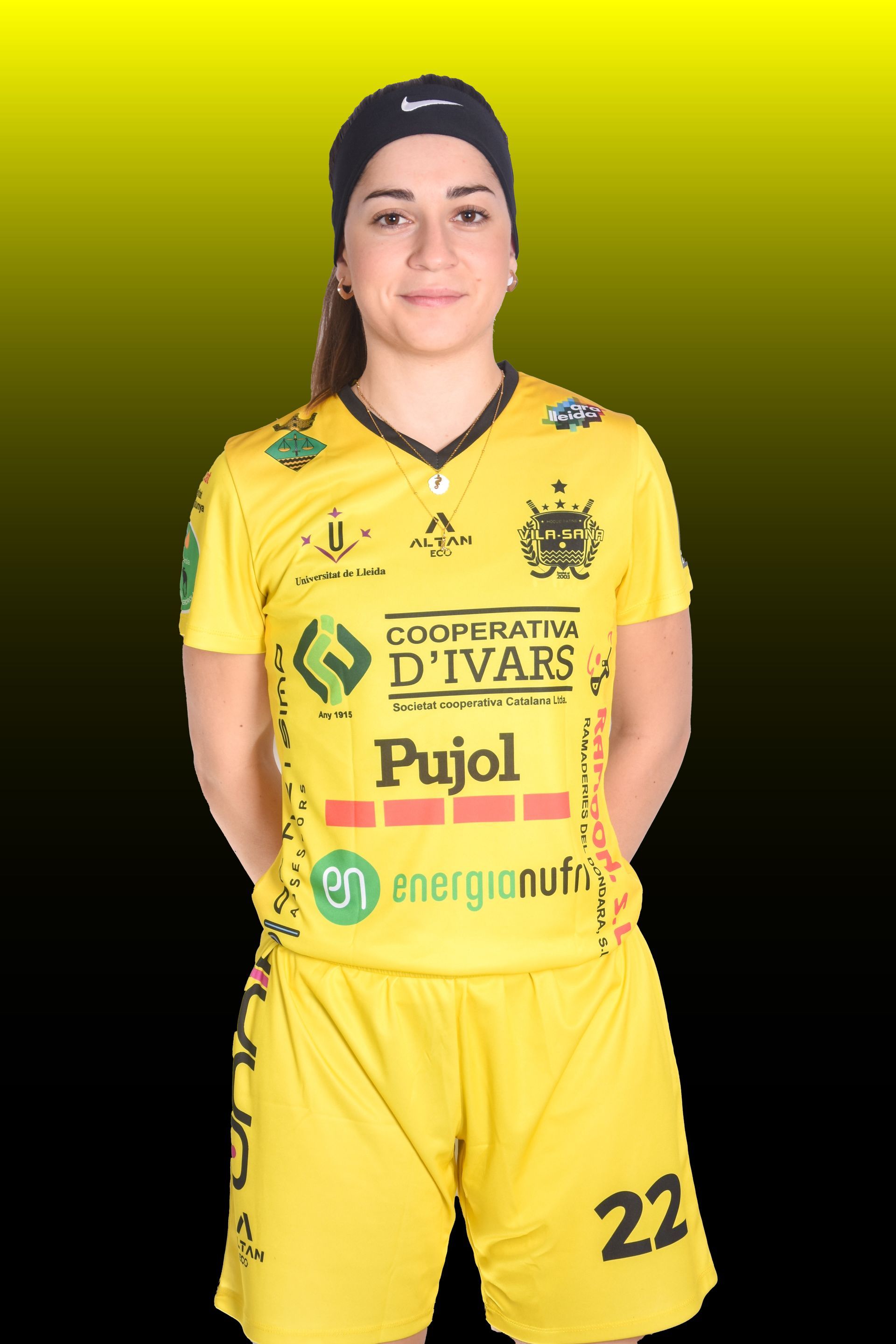 Una mujer con camiseta amarilla y un hombre mayor con camisa polo posan en el interior de una pista de patinaje.