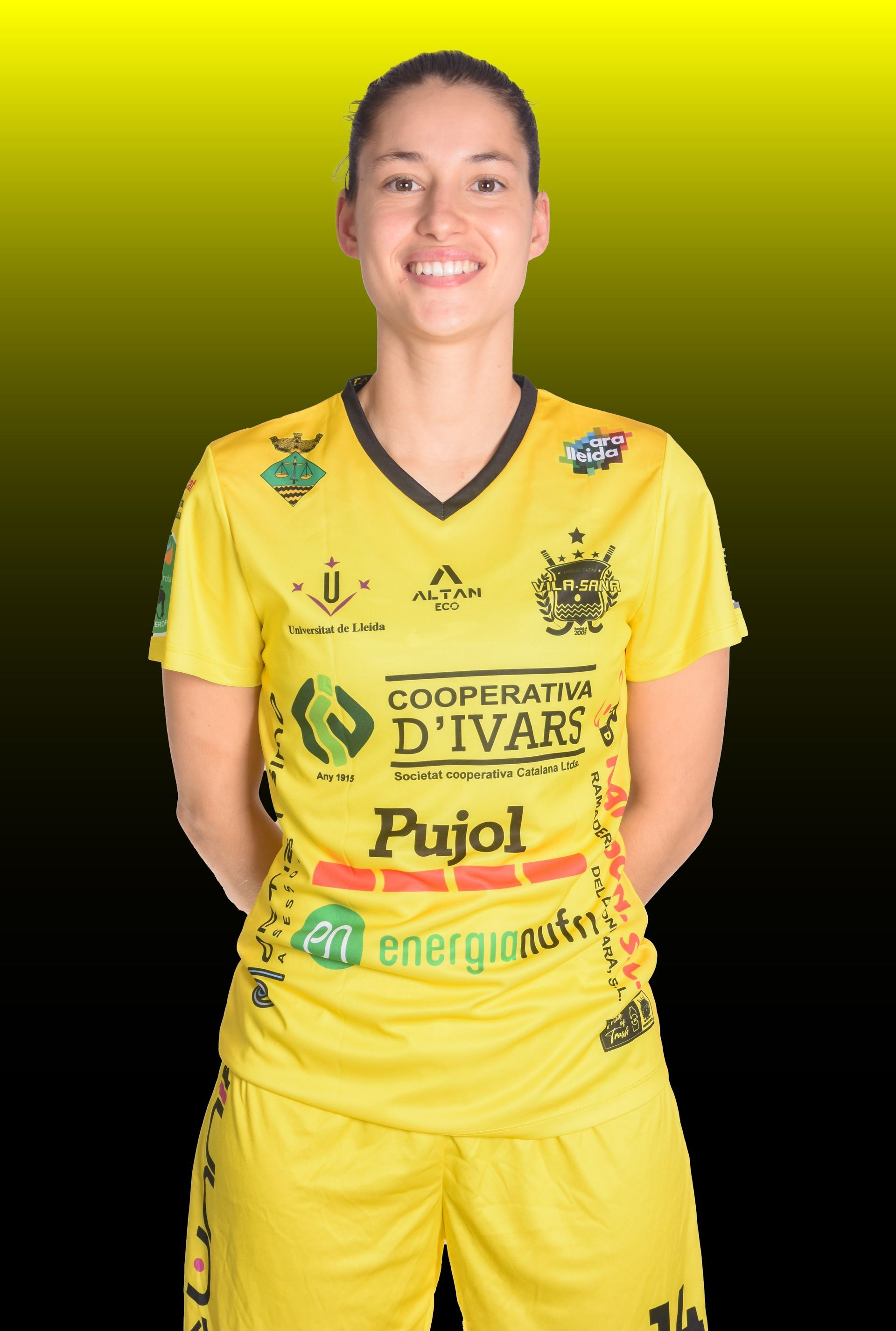 Jugadora de hockey sobre patines con camiseta amarilla, regateando hacia la portería. El portero al fondo.