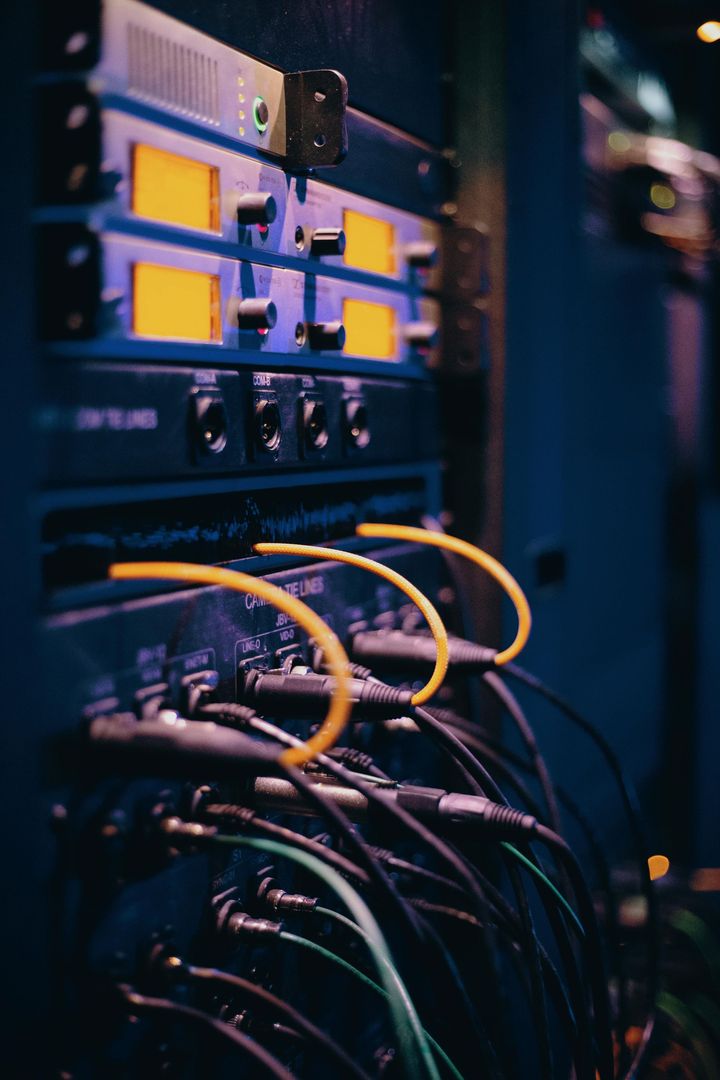 Rack pour équipement audio avec câbles et touches de jaune.