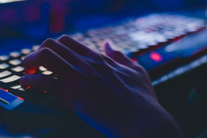 Saisie manuelle sur un clavier rétroéclairé ; éclairage bleu et rouge.