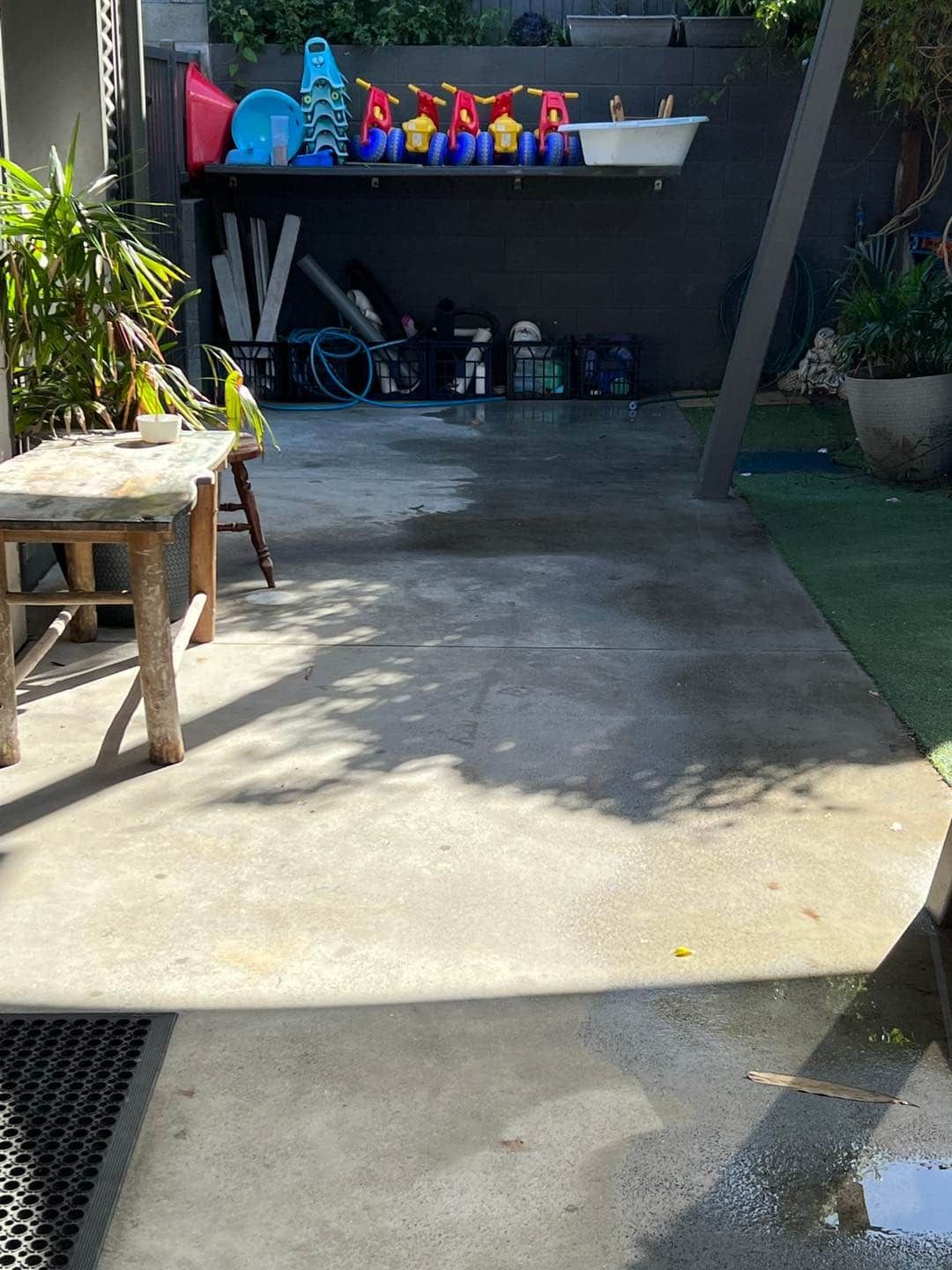 A Patio With A Table And Chairs And A Shelf With Toys On It — Gibbo’s Lawns & Property Maintenance In Salamander Bay, NSW