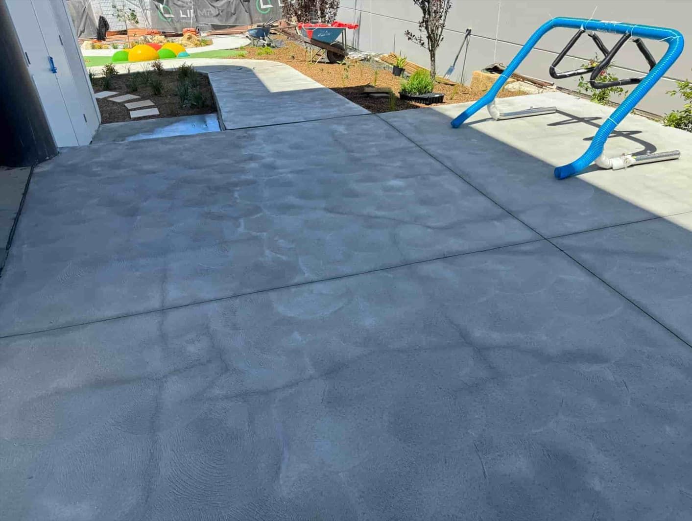 A Concrete Patio With A Blue Railing And A Swing — Gibbo’s Lawns & Property Maintenance In Salamander Bay, NSW