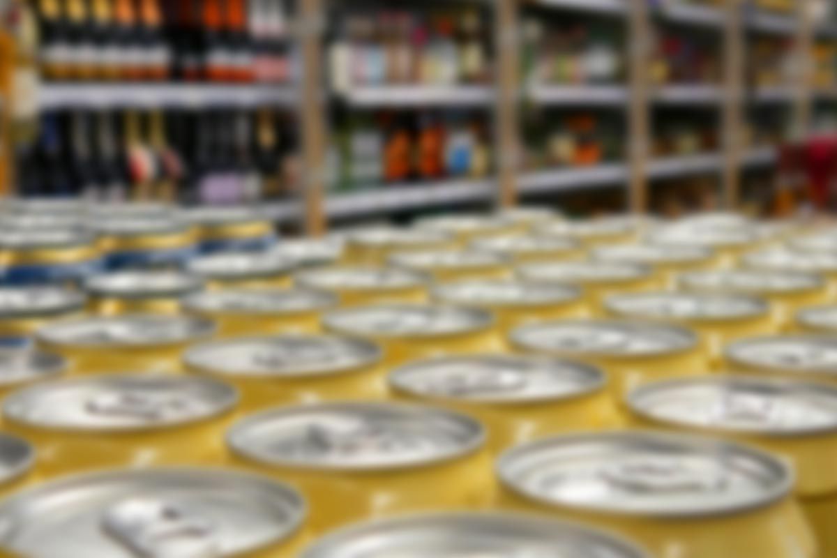 A row of cans of soda are lined up in a store.