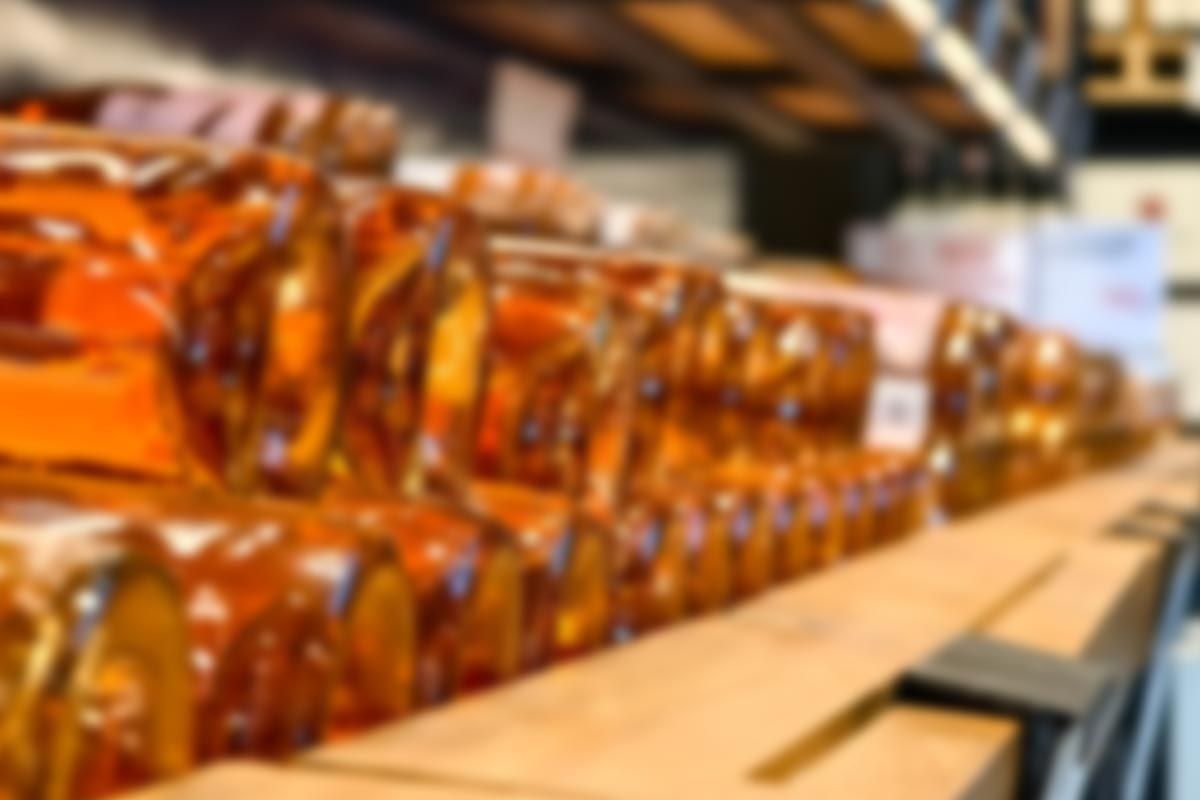 A blurred image of a row of bottles on a shelf in a store.