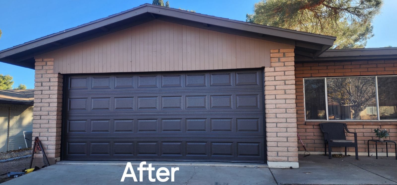 A picture of a house with a garage door that has been painted black.