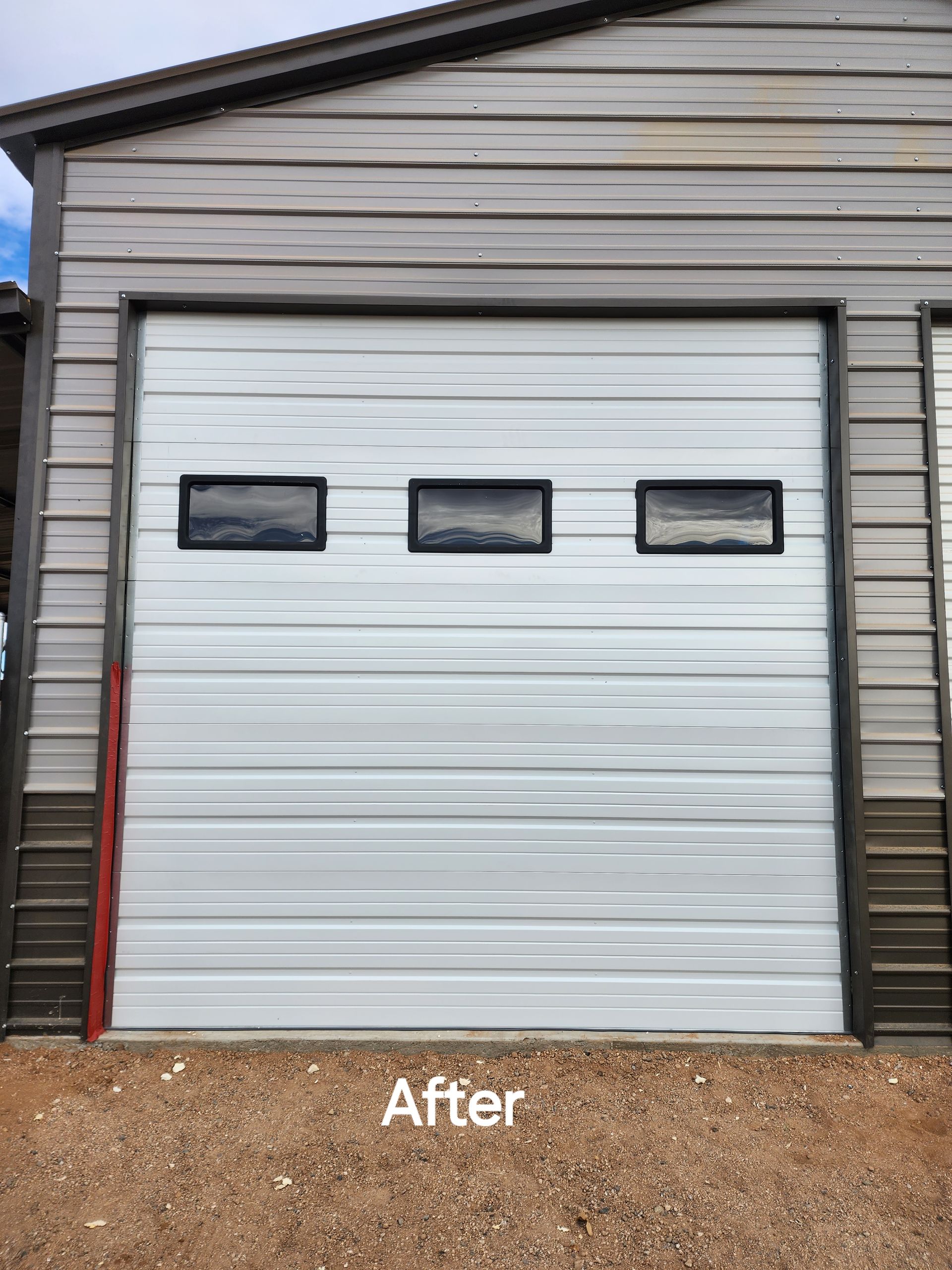 A white garage door is sitting in front of a building.