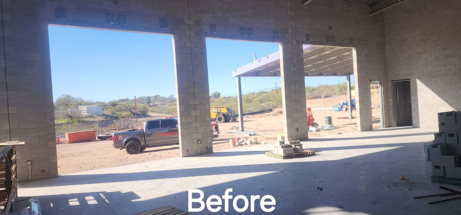 A truck is parked in front of a building under construction.