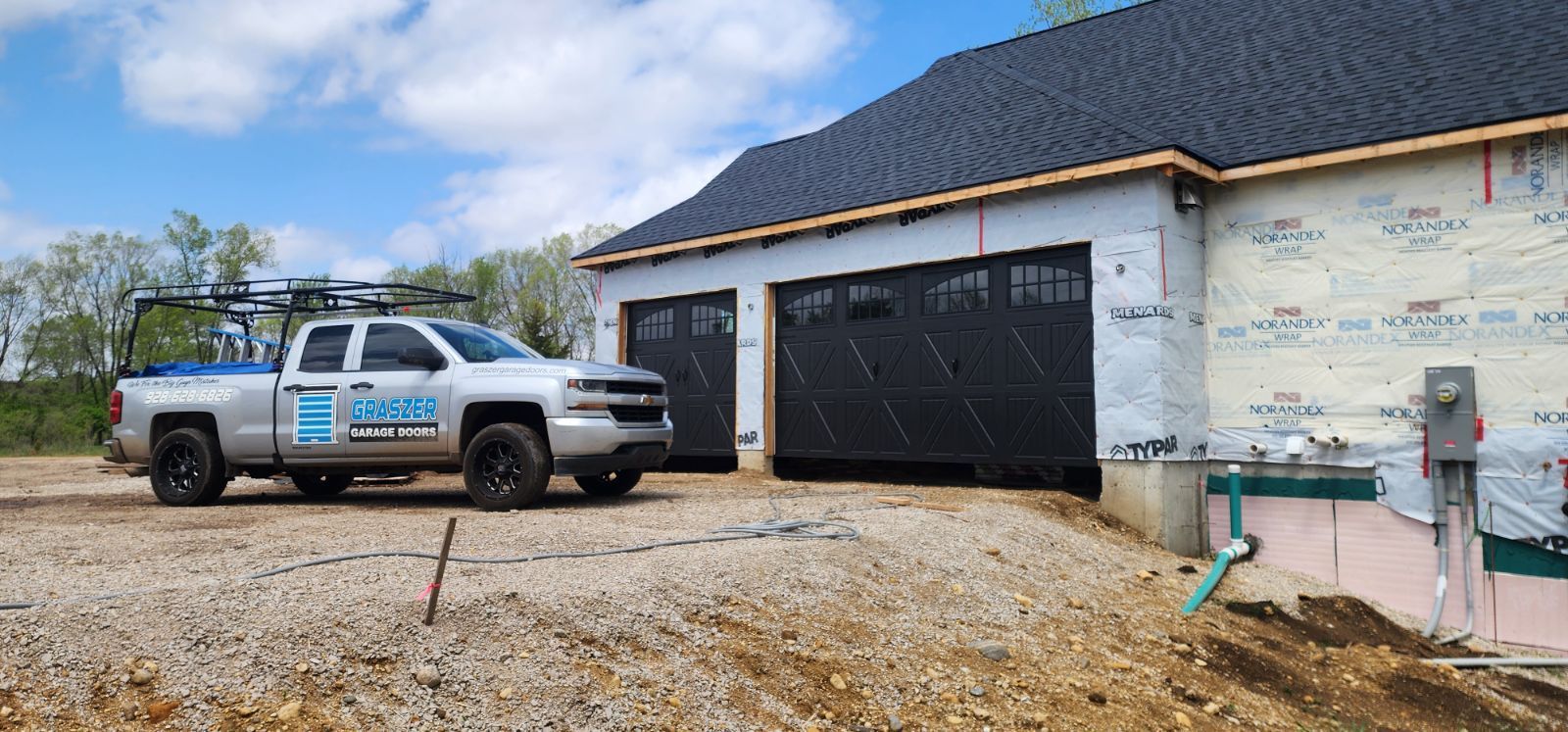 A truck is parked in front of a house under construction.