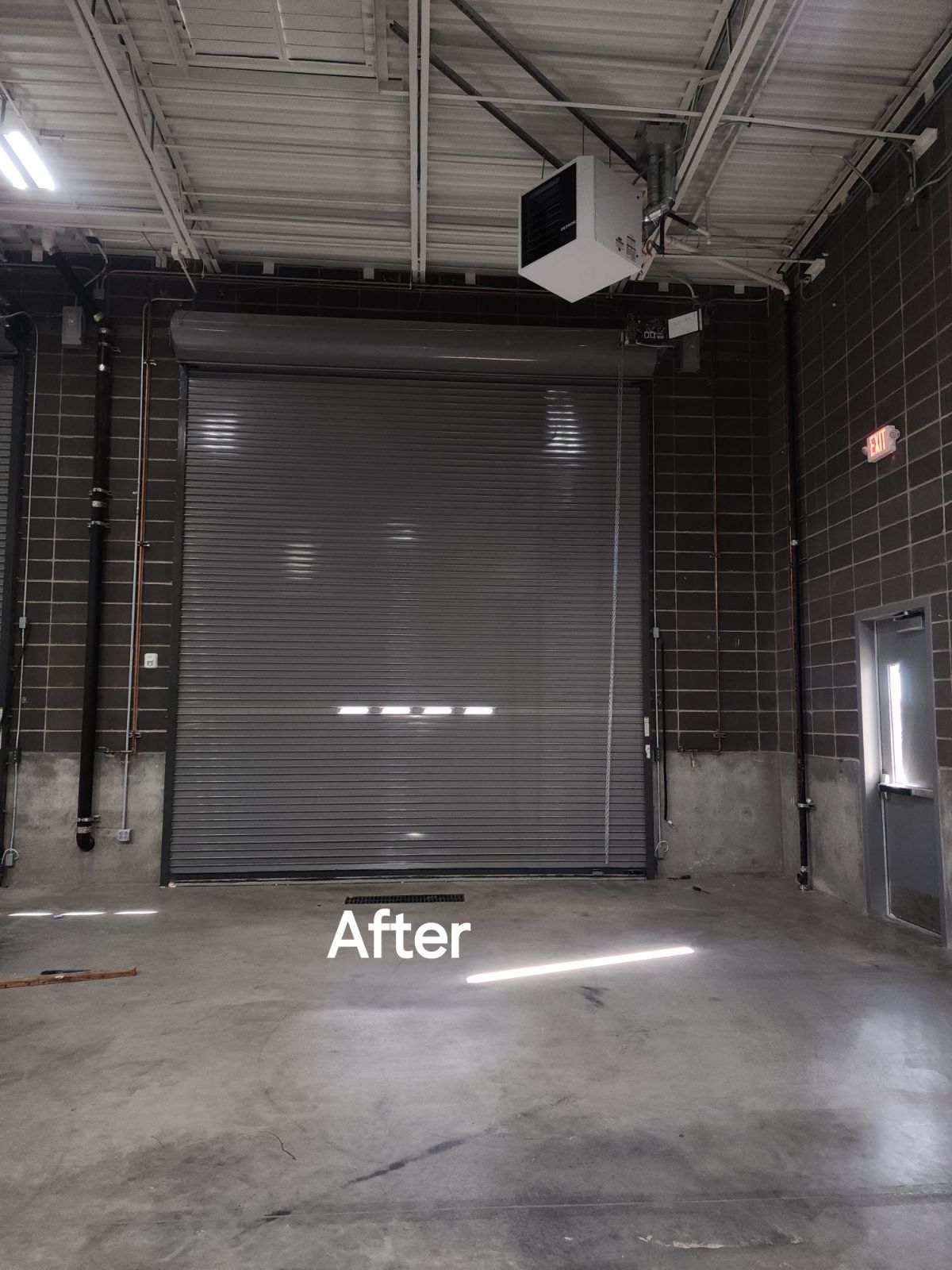 An empty warehouse with a garage door and a sign that says after