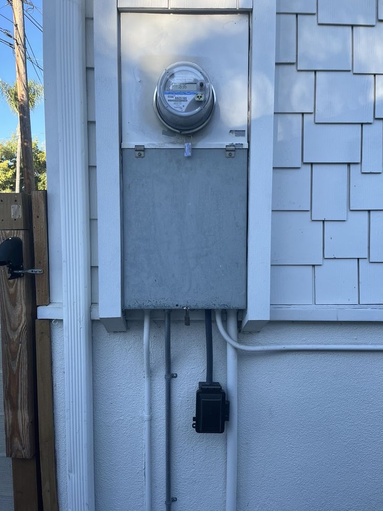 A white house with a meter on the side of it