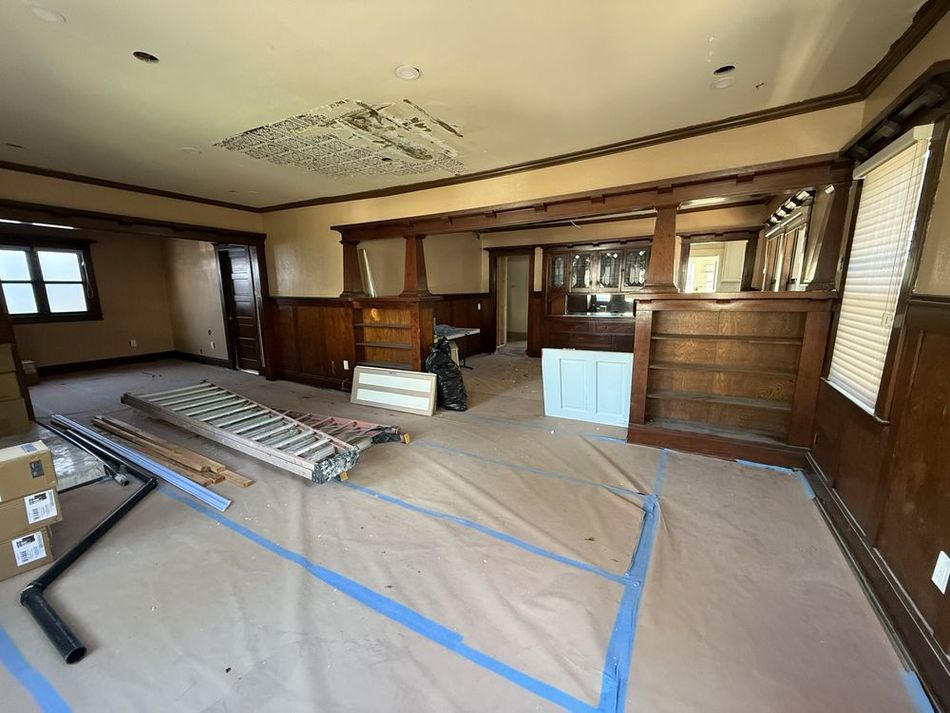 A large room with wood paneling and blue tape on the floor.