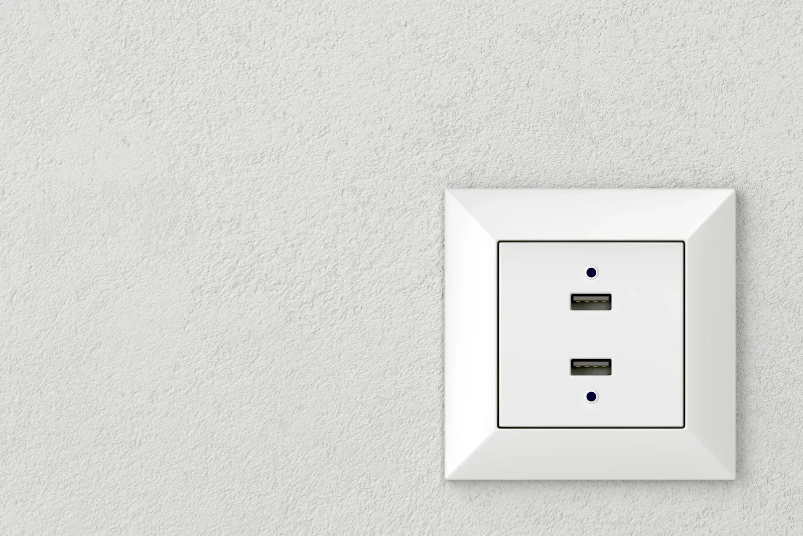 A white electrical outlet with two usb ports on a white wall.