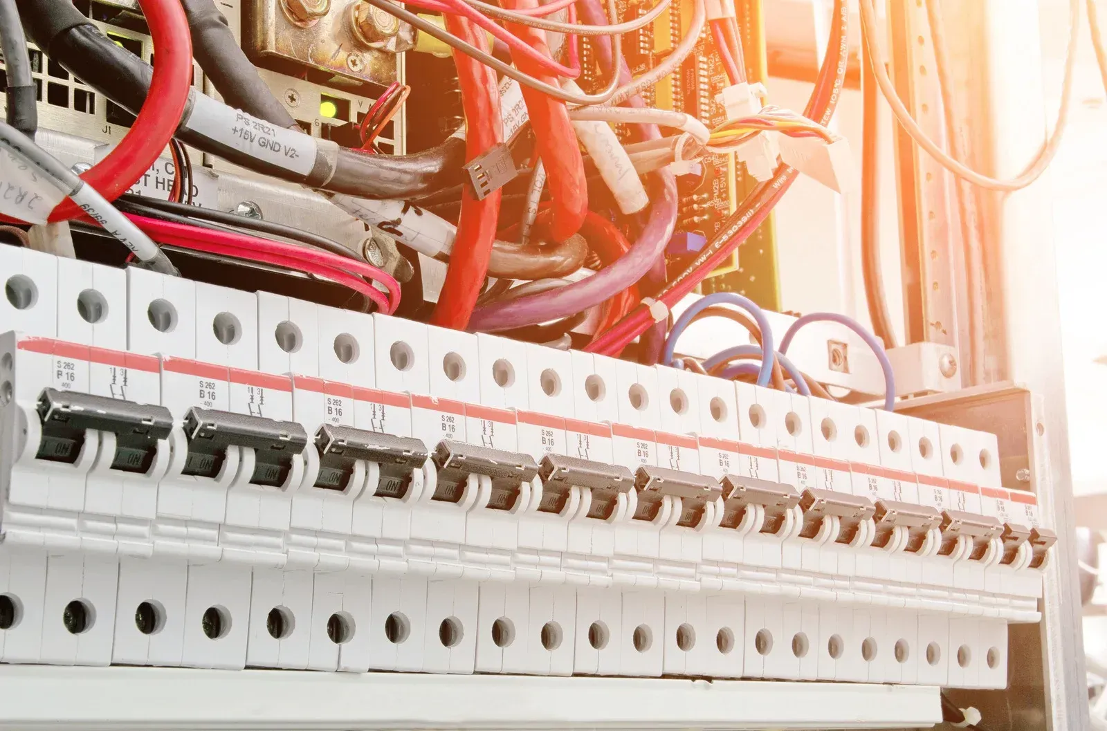 A close up of a electrical box with a lot of wires coming out of it.