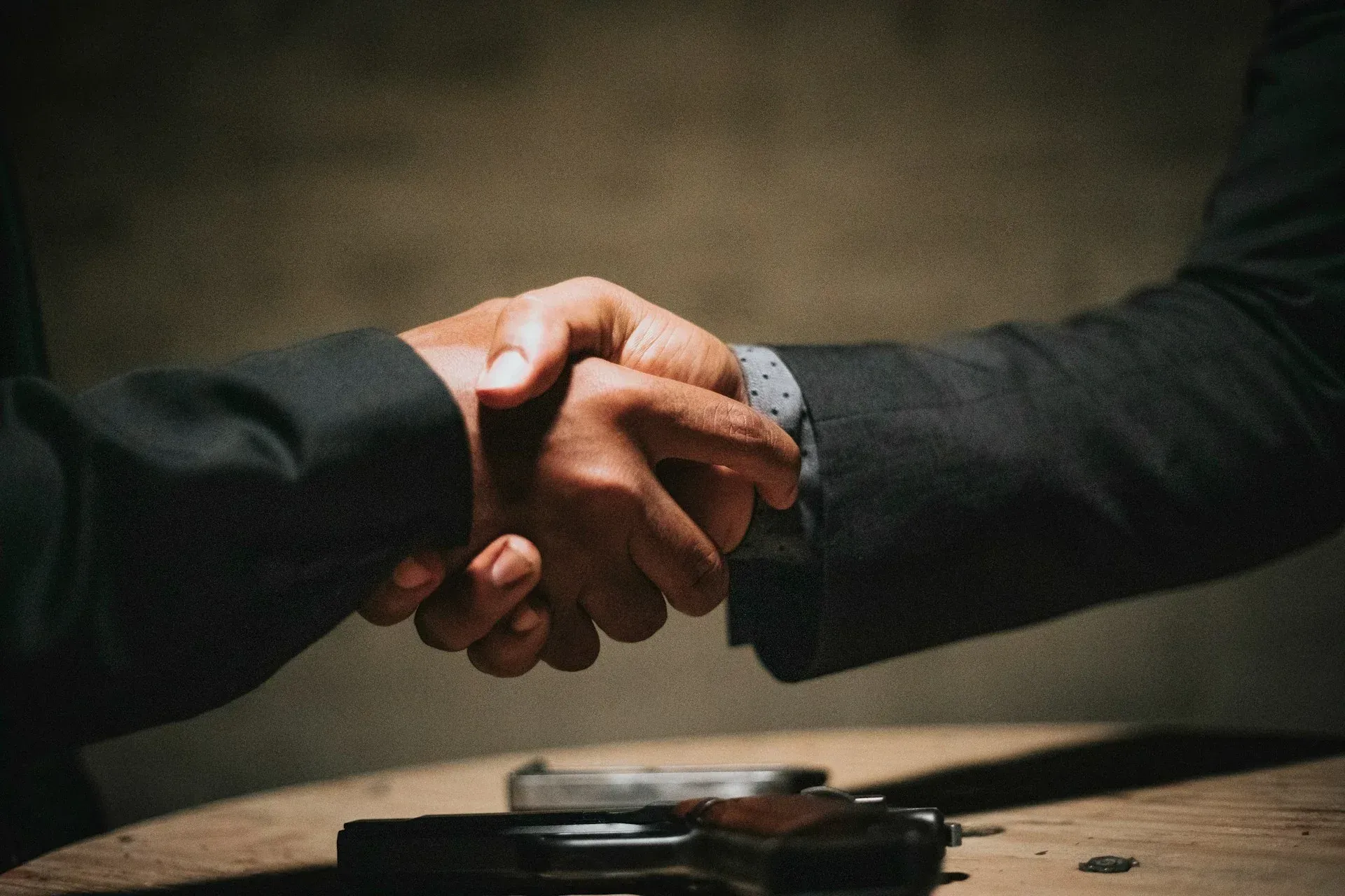 A man in a suit is shaking hands with another man in a suit.
