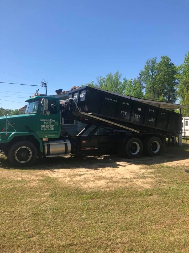 A dump truck is parked in a grassy field.