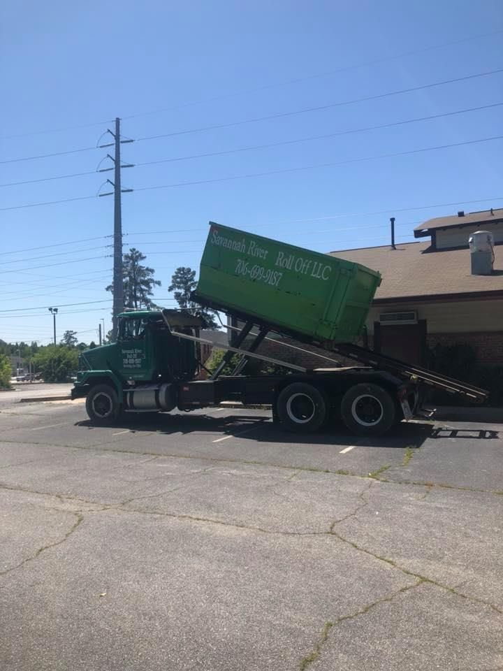 A dump truck with a green container on the back of it