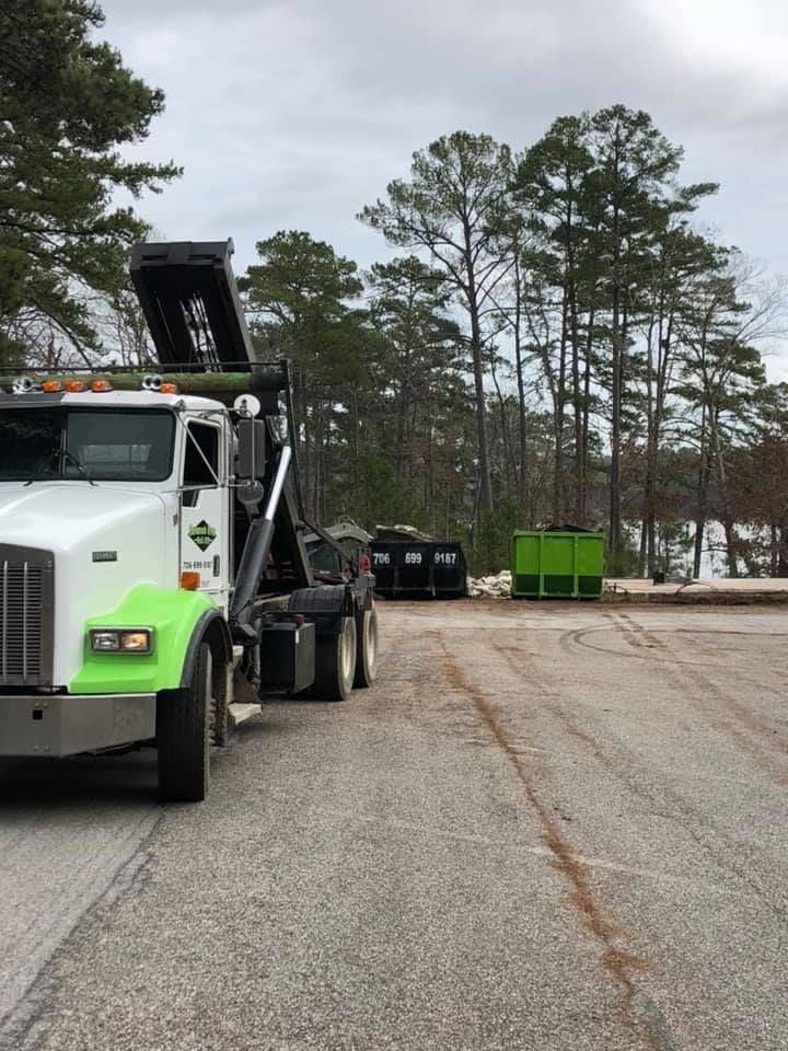 A dump truck is parked on the side of the road in a parking lot.