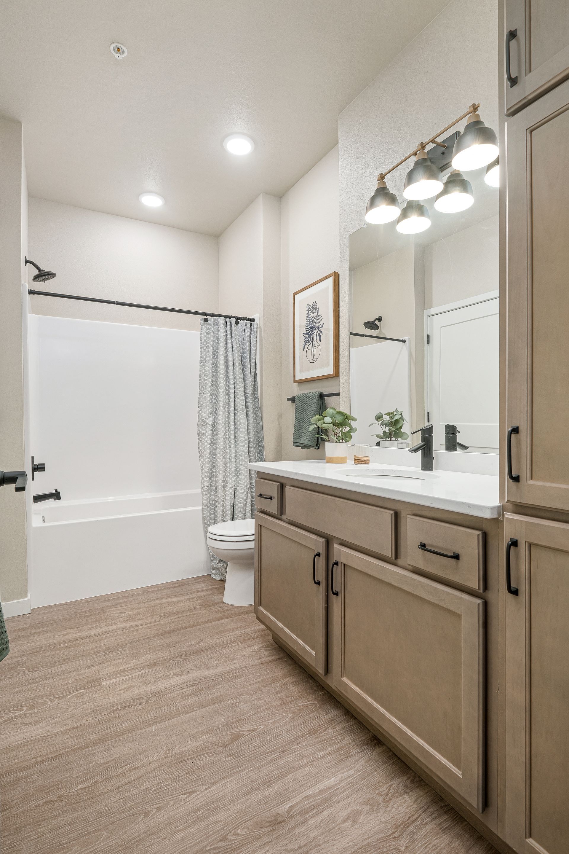 A bathroom with a sink , toilet , tub and mirror.