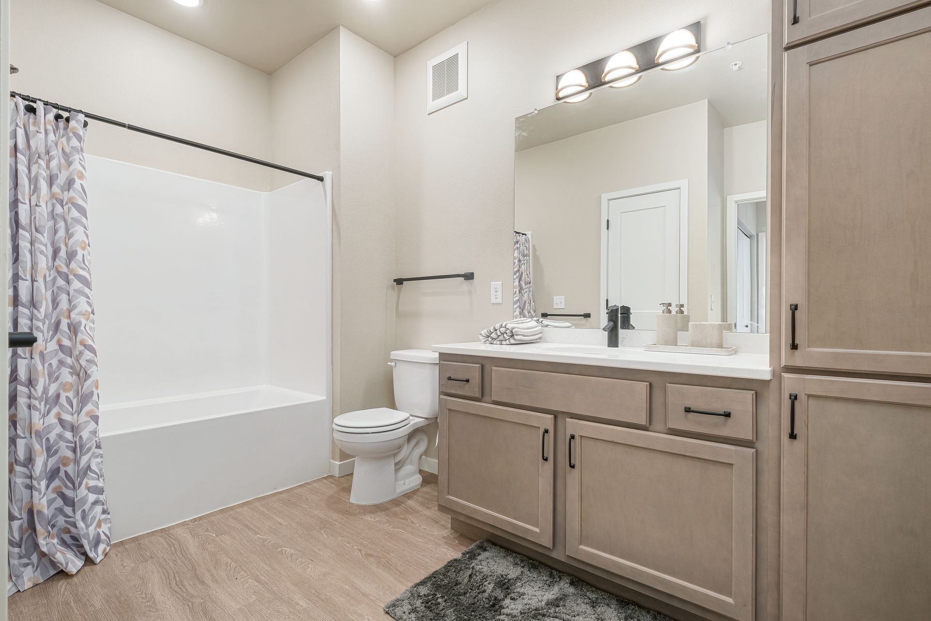 A bathroom with a toilet , sink , and bathtub.