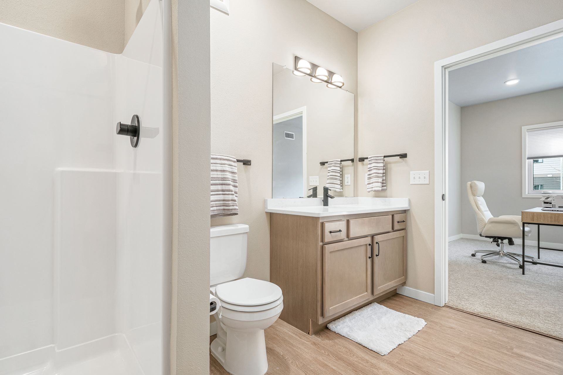 A bathroom with a toilet , sink , and mirror.