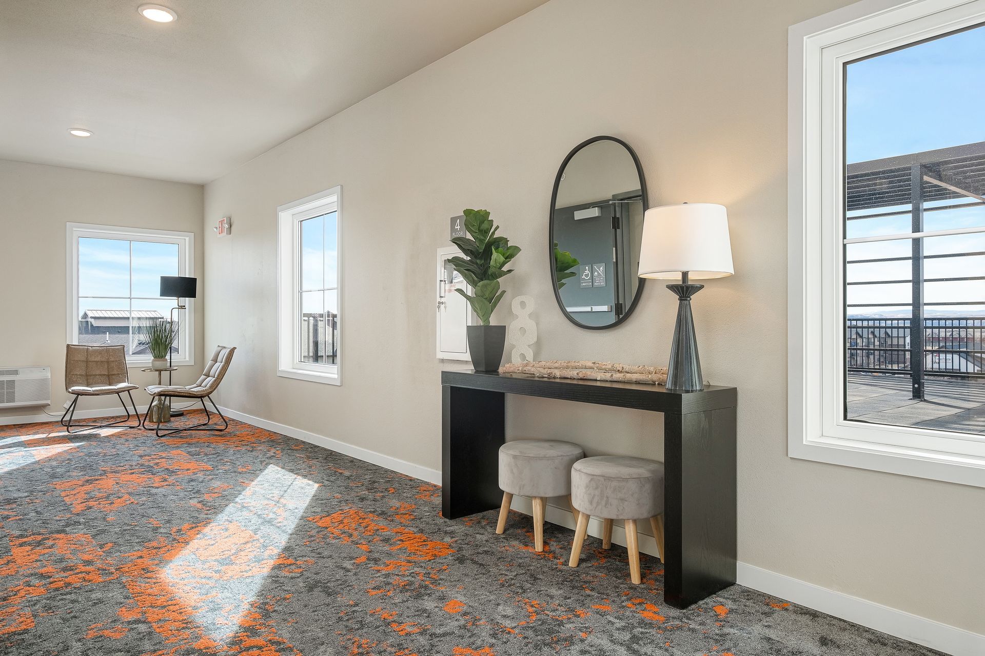 A living room with a table , chairs , lamps and a mirror.