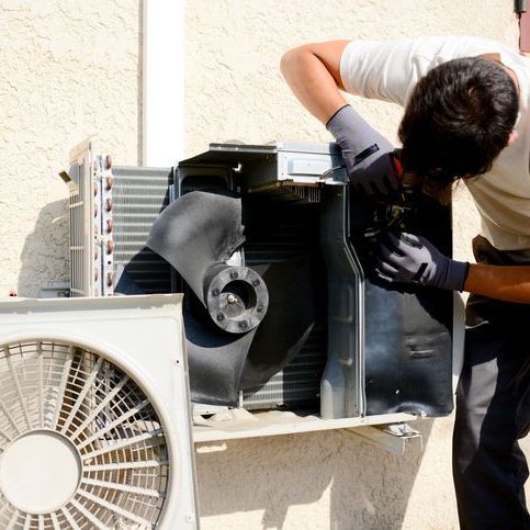 a white air conditioner is sitting on a metal stand outside