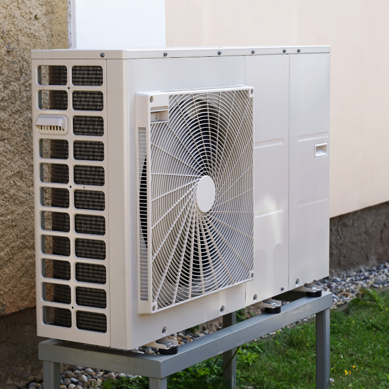 a white air conditioner is sitting outside of a building