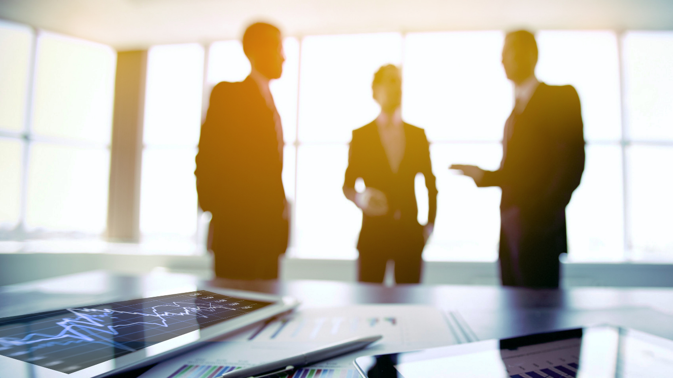 Business professionals meeting with financial charts on tablet