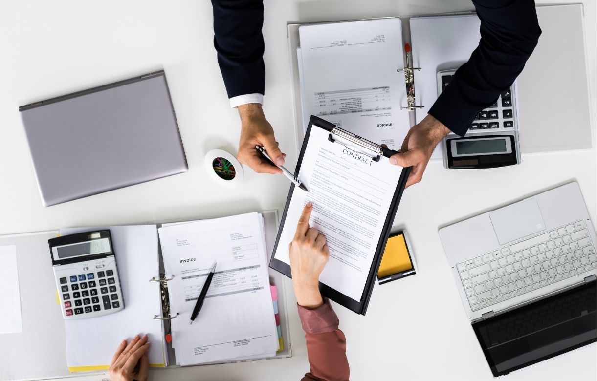 Business professionals reviewing financial documents and data with a laptop and calculator 