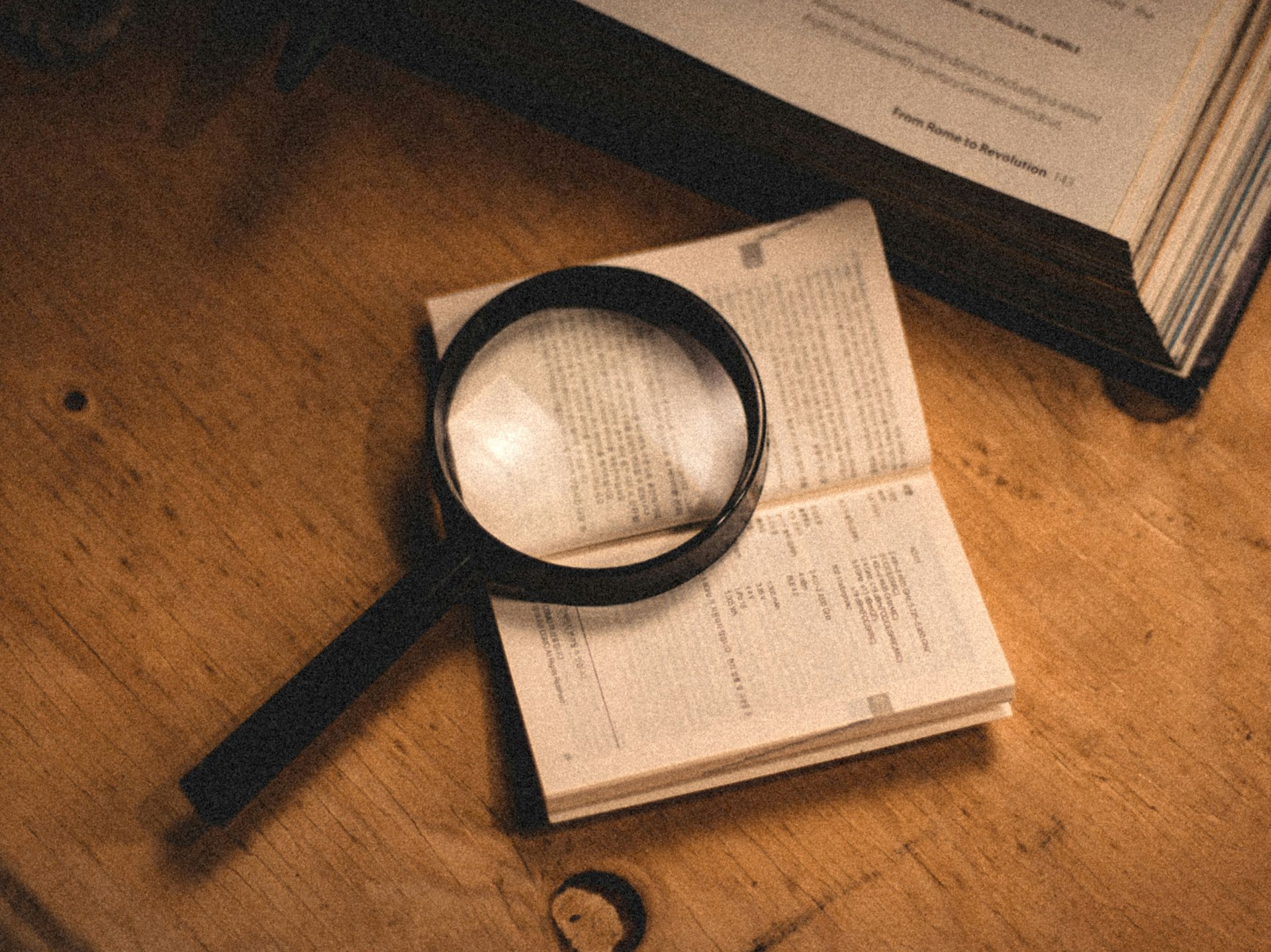 Close-up of magnifying glass resting on financial documents, representing forensic accounting invest