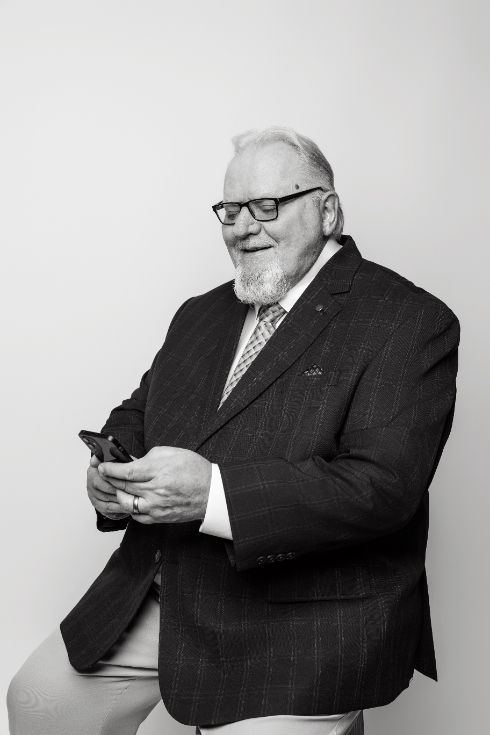 Couple dancing in a living room, woman laughing with arm raised, man behind her.