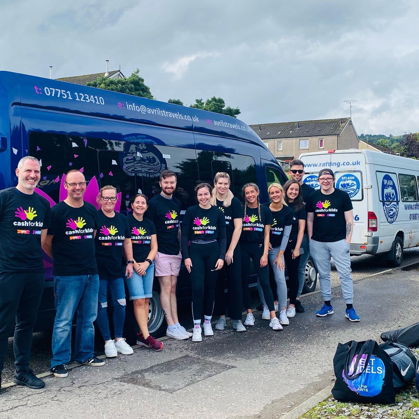 A group of people are posing for a picture in front of a bus.