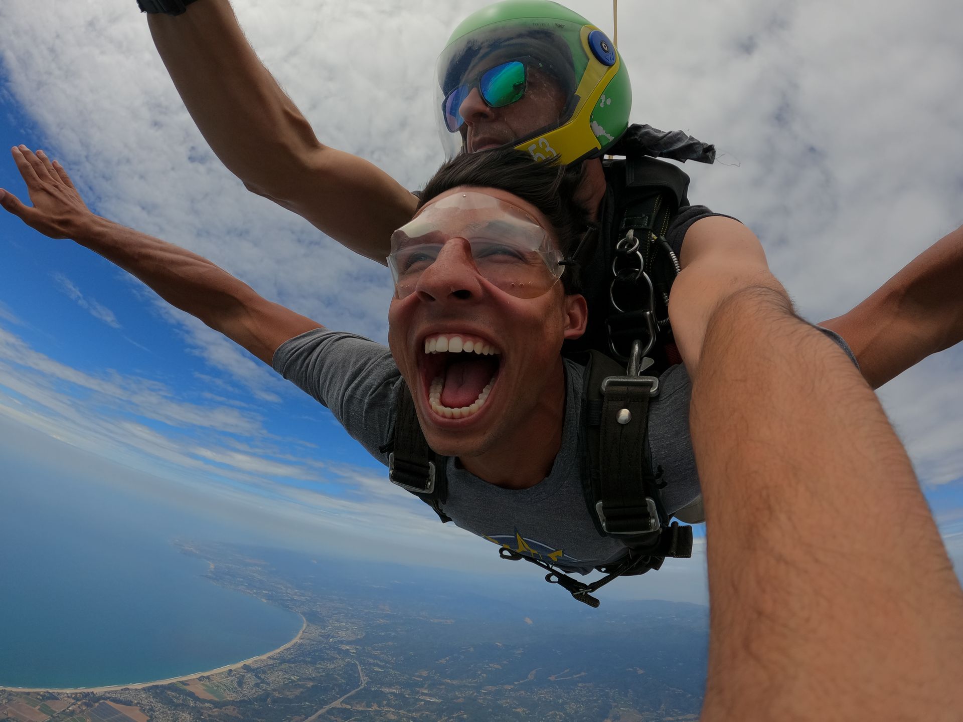 Male tandem skydive student with huge smile during freefall at Skydive Santa Cruz.