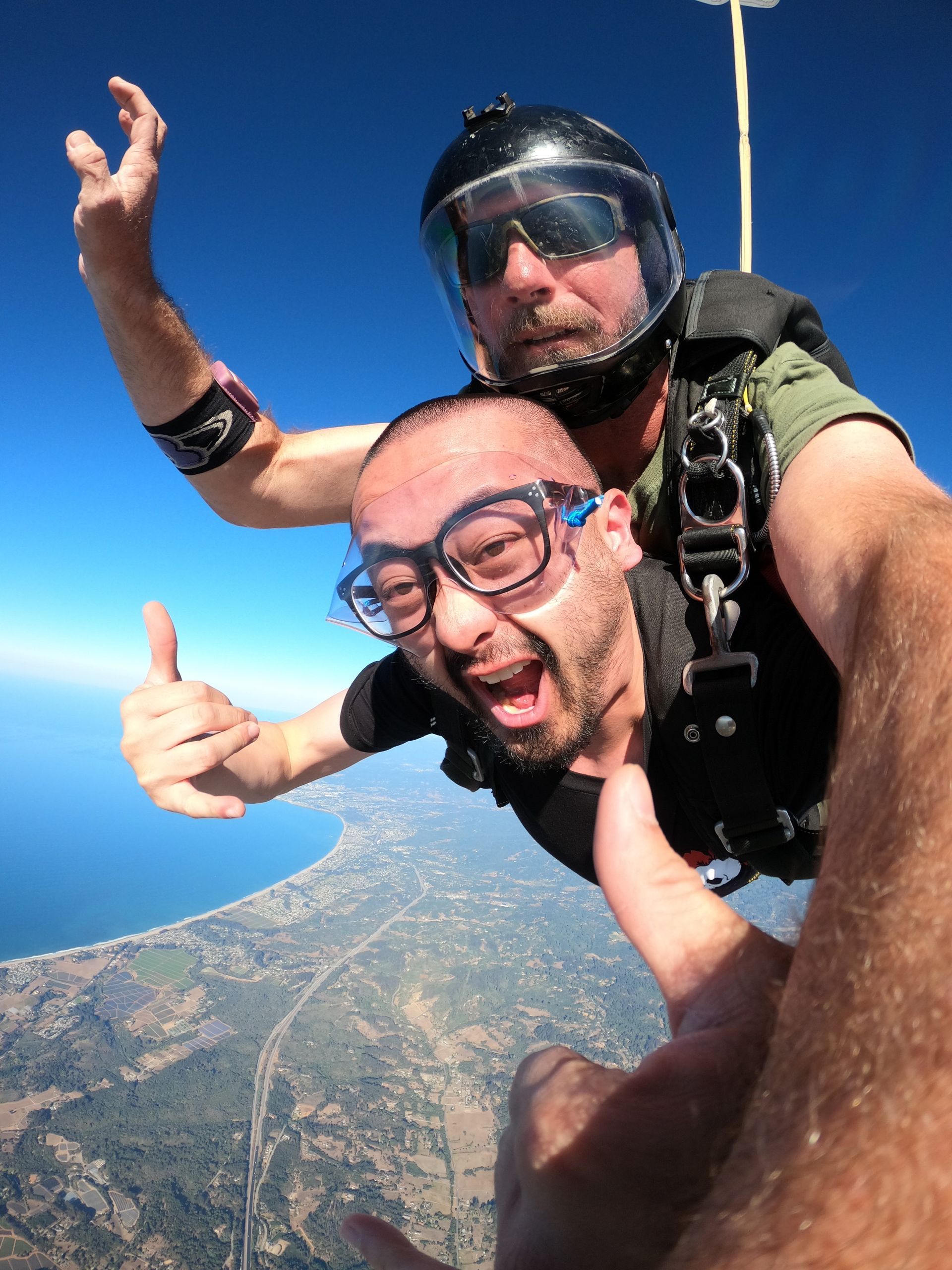 Excited man geeks camera during tandem skydive over Santa Cruz. 