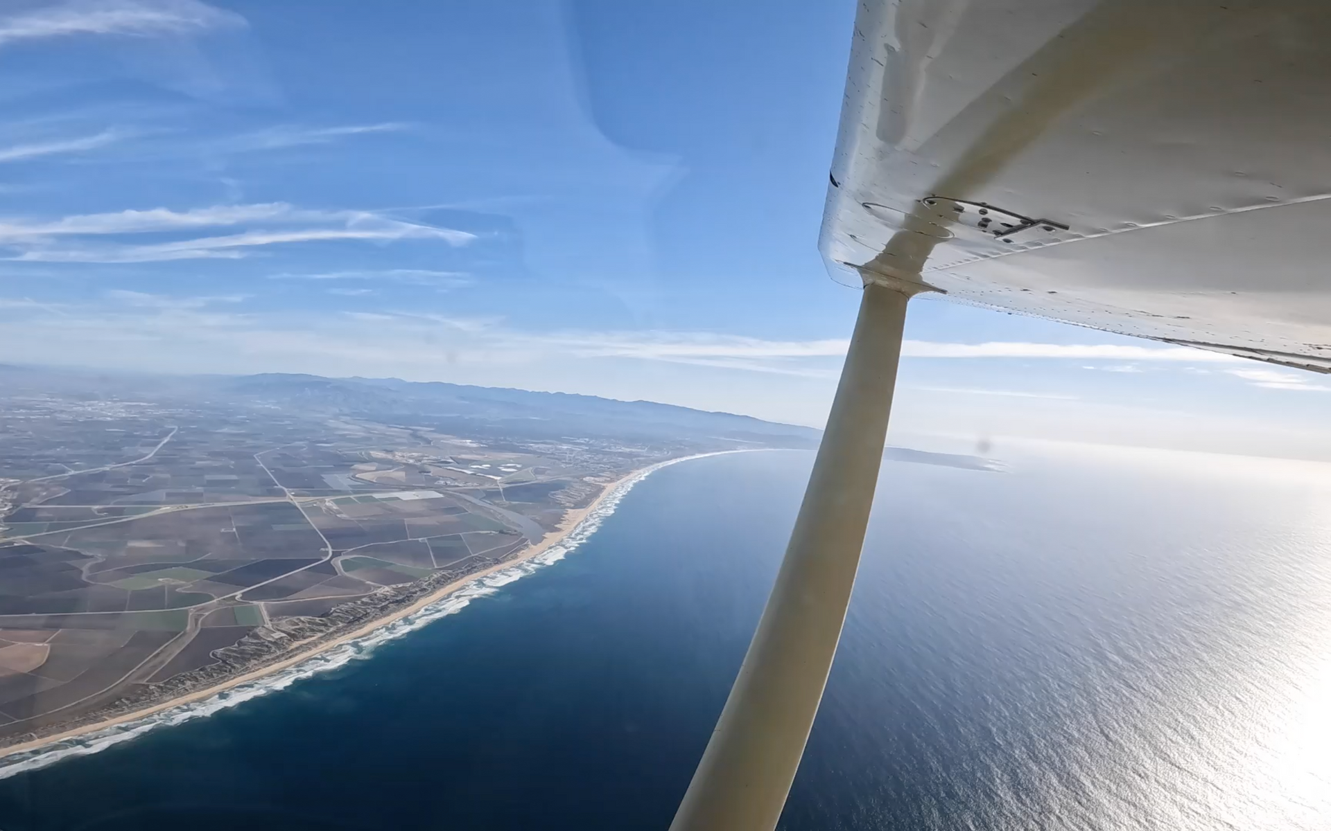 Skydive Santa Cruz's jump plane flies over the Pacific Ocean during a scenic climb prior to jumping.