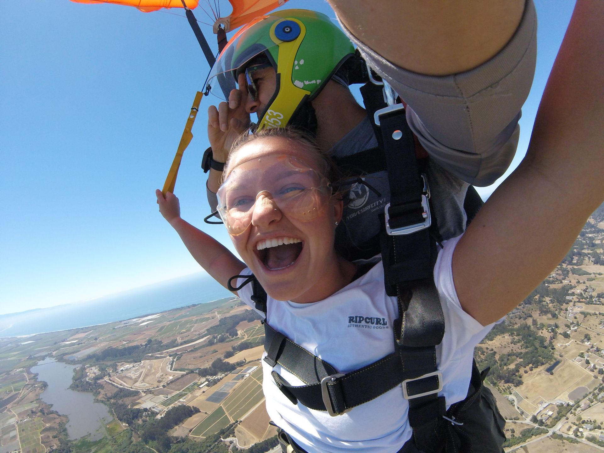 A woman wearing a helmet is taking a picture of herself in the air