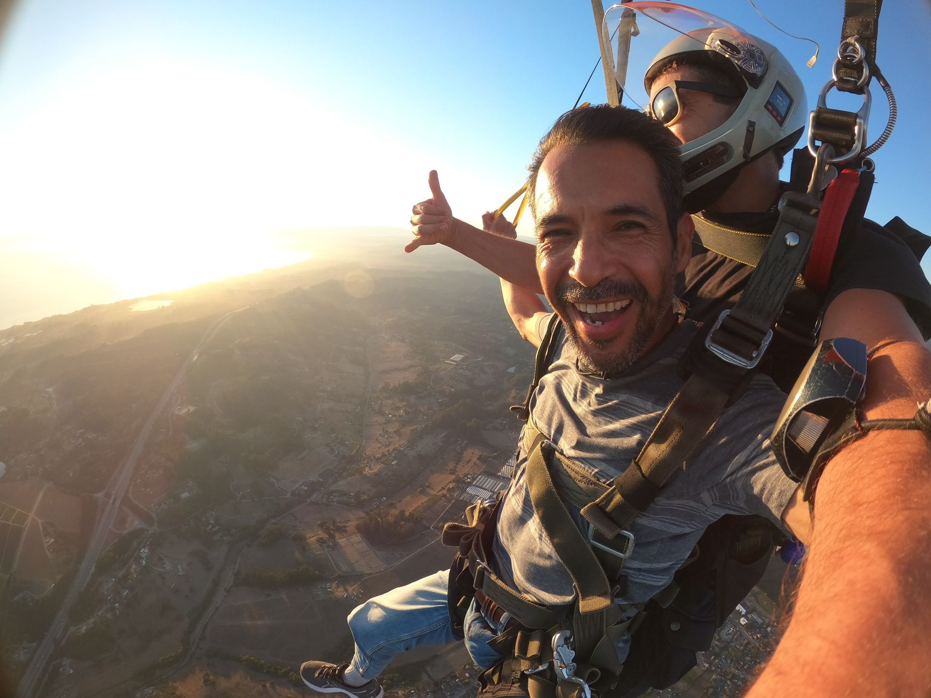 Tandem skydive pair during sunset near the ocean in Santa Cruz. 