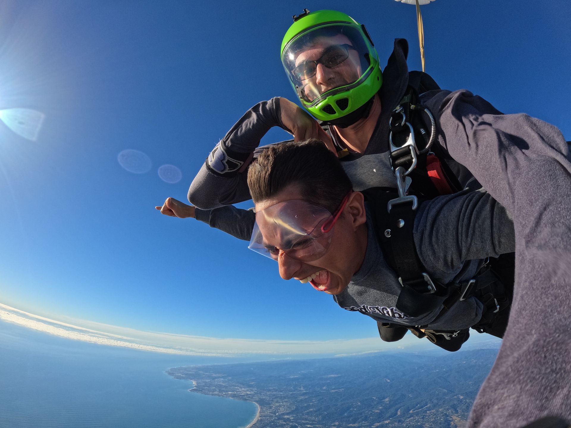 Tandem skydive pair during freefall near the Pacific ocean at Skydive Santa Cruz. 