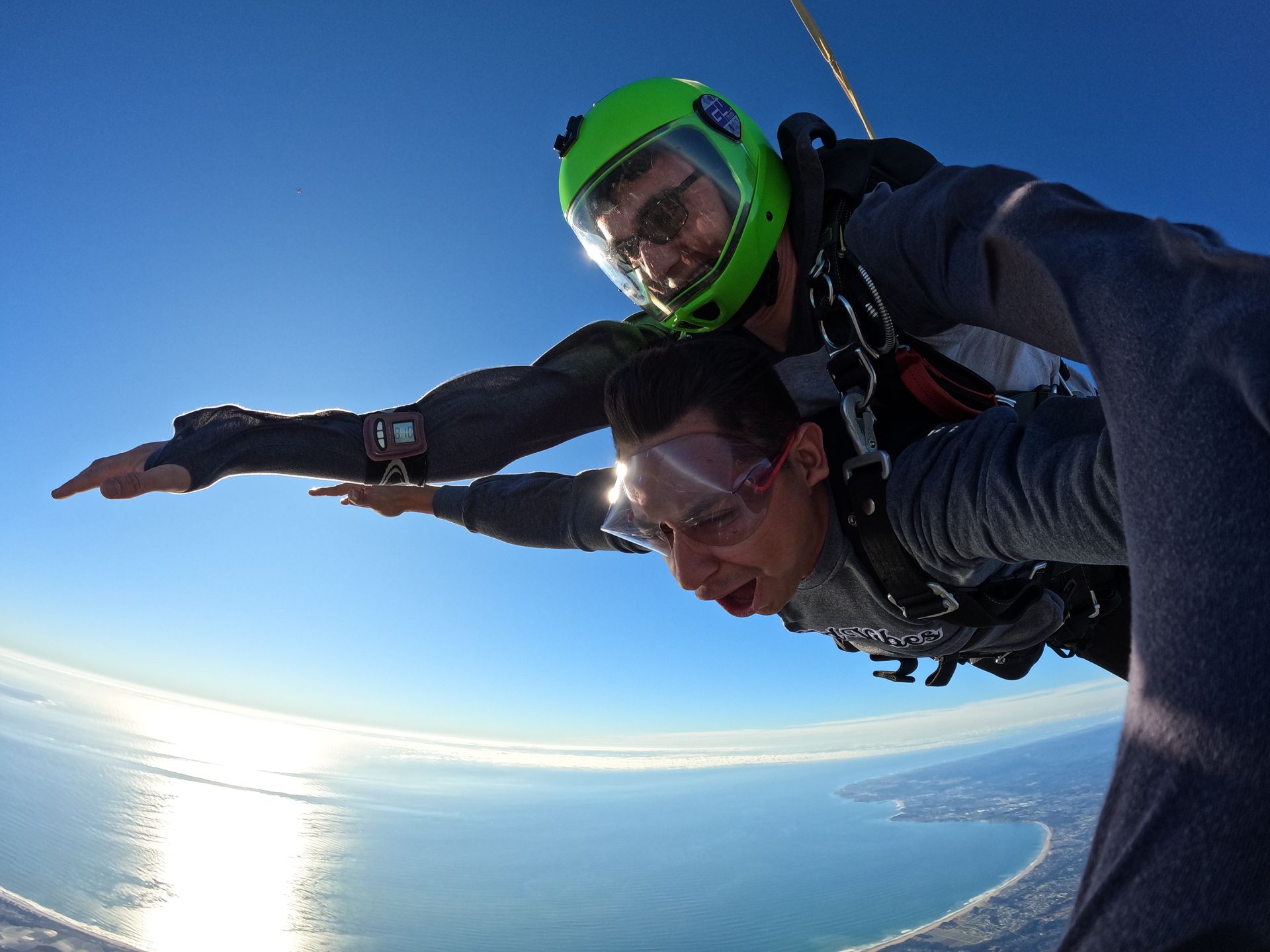 Tandem skydive pair freefall next to the Pacific Ocean at Skydive Santa Cruz. 