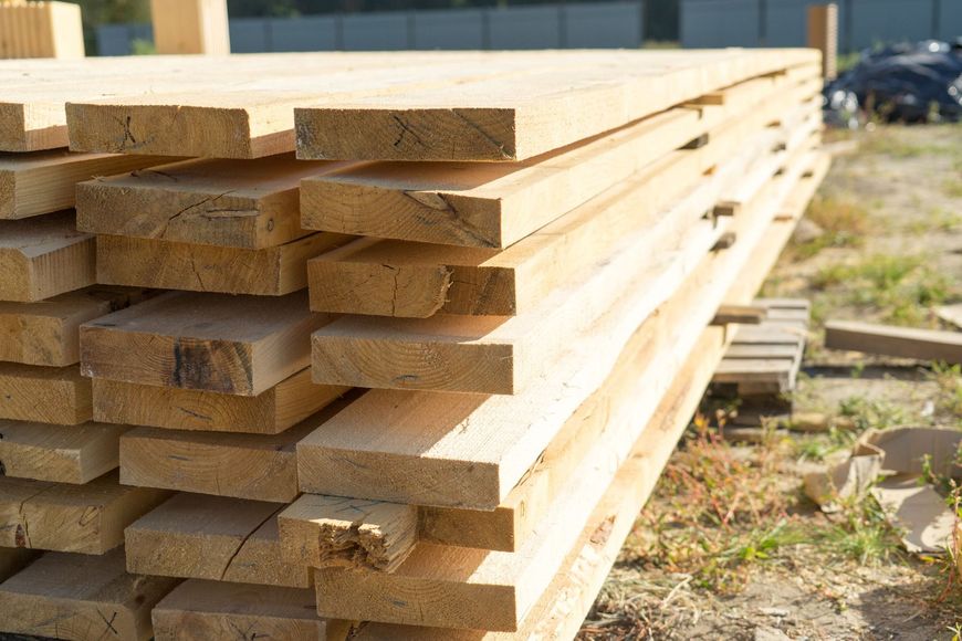 A pile of wood sitting on top of each other on a construction site.