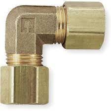 A close up of a brass elbow on a white background.