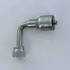 A close up of a stainless steel hose fitting on a white surface.